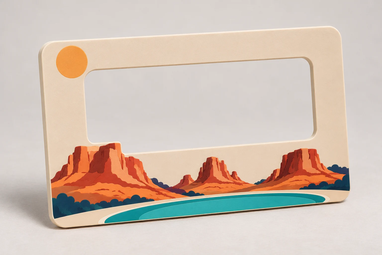 Sand-colored handheld viewfinder with a cutout window and red-rock peak outlines along its lower frame