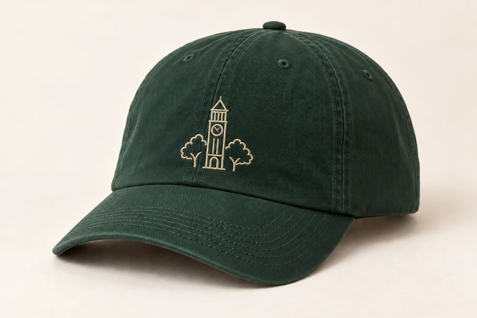 Pine-green cap with cream clock-tower and tree-canopy embroidery